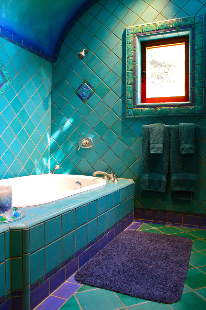 Eclectic bathroom in Santa Barbara with a drop-in tub, blue tile and turquoise floor.