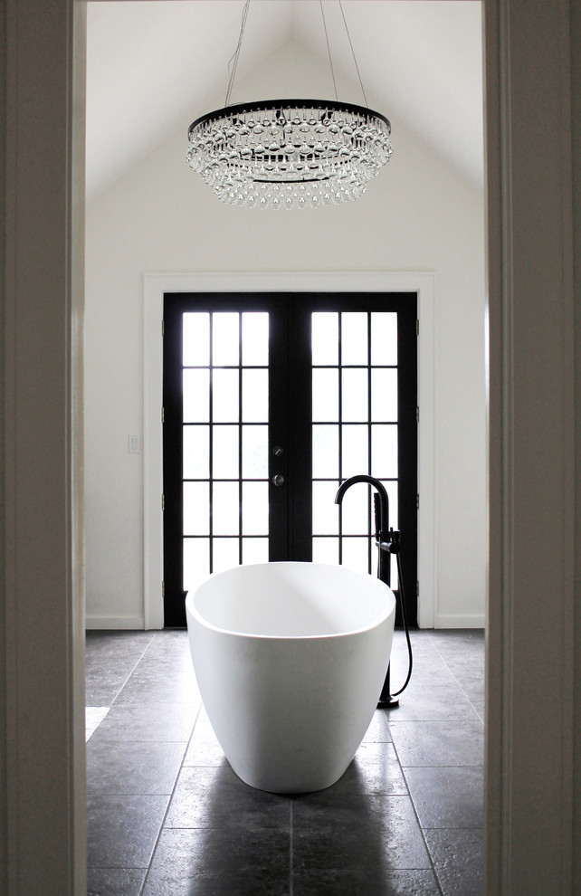 This is an example of a transitional master bathroom in New York with a freestanding tub and white walls.