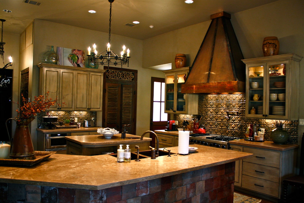 Kitchen - large rustic kitchen idea in Austin with a farmhouse sink, raised-panel cabinets, distressed cabinets, brown backsplash, stainless steel appliances and two islands
