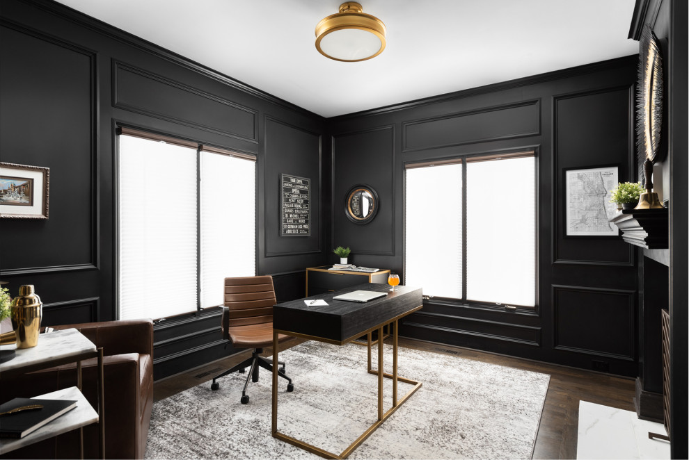 Inspiration for a large classic study in Chicago with black walls, dark hardwood flooring, a two-sided fireplace, a stone fireplace surround, a freestanding desk and wainscoting.