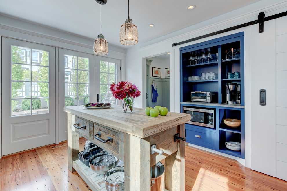 Country kitchen in Boston with shaker cabinets, blue cabinets, medium hardwood floors, with island, brown floor and grey benchtop.