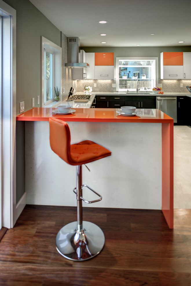Design ideas for a mid-sized contemporary u-shaped eat-in kitchen in San Francisco with an undermount sink, flat-panel cabinets, orange cabinets, quartz benchtops, grey splashback, porcelain splashback, stainless steel appliances, porcelain floors, a peninsula and orange benchtop.