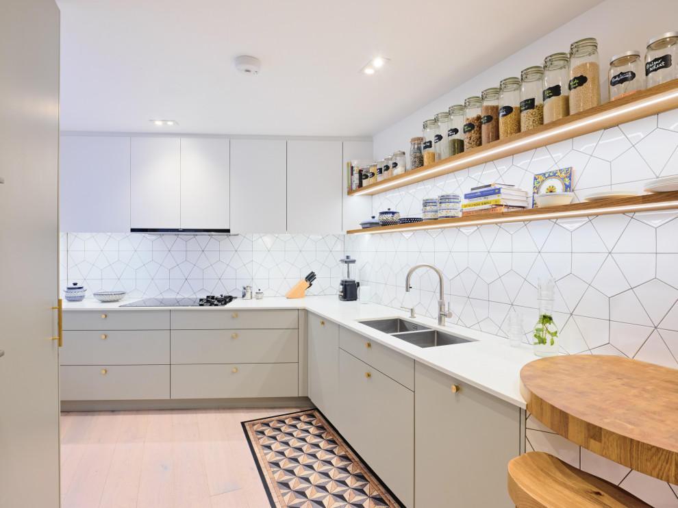 Design ideas for a mid-sized contemporary l-shaped separate kitchen in London with an undermount sink, flat-panel cabinets, grey cabinets, solid surface benchtops, white splashback, ceramic splashback, black appliances, light hardwood floors, no island and yellow benchtop.