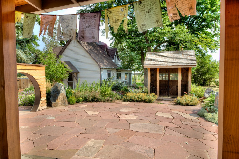 Foto di un ampio giardino xeriscape country esposto in pieno sole dietro casa con pavimentazioni in pietra naturale