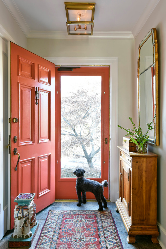 Photo of a traditional entryway in New York with beige walls, a single front door, a red front door and grey floor.