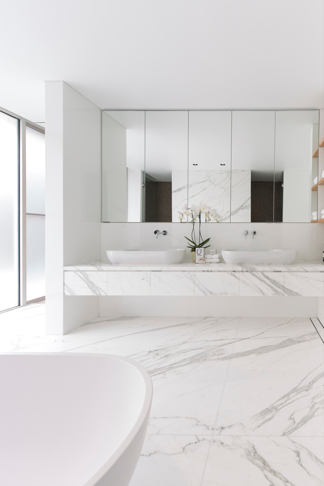 Photo of a large modern master bathroom in Sydney with a vessel sink, a freestanding tub, white tile, white walls, marble benchtops, marble and white benchtops.