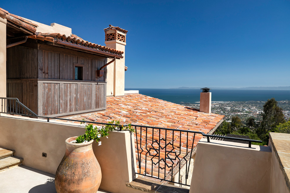Large mediterranean three-storey beige house exterior in Santa Barbara with a shed roof and a tile roof.