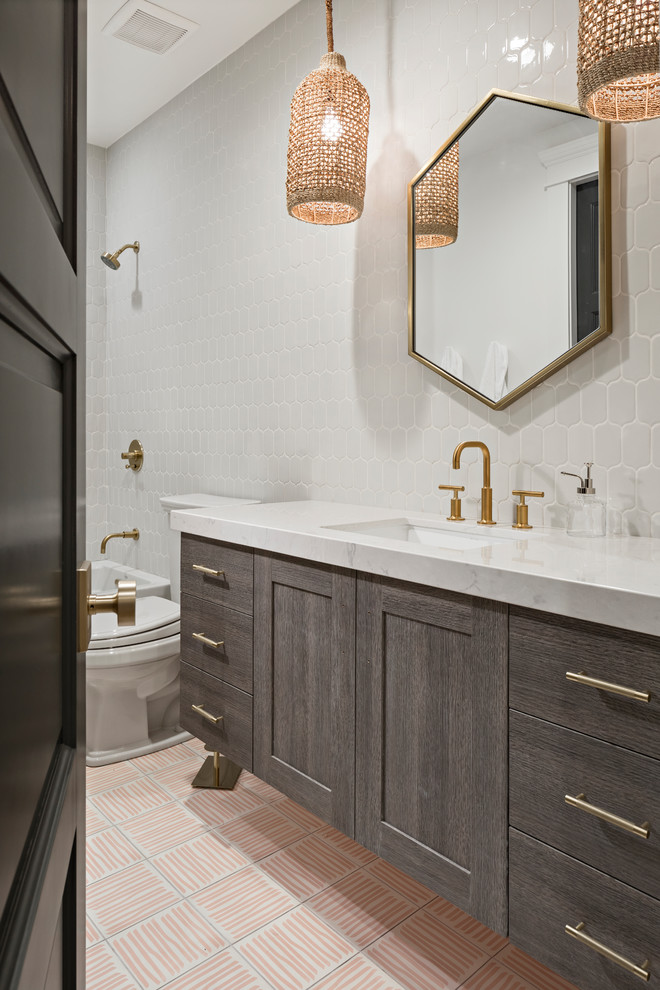 Large transitional kids bathroom in Phoenix with flat-panel cabinets, grey cabinets, an alcove tub, an open shower, a one-piece toilet, white tile, ceramic tile, white walls, cement tiles, an undermount sink, engineered quartz benchtops, pink floor and a shower curtain.