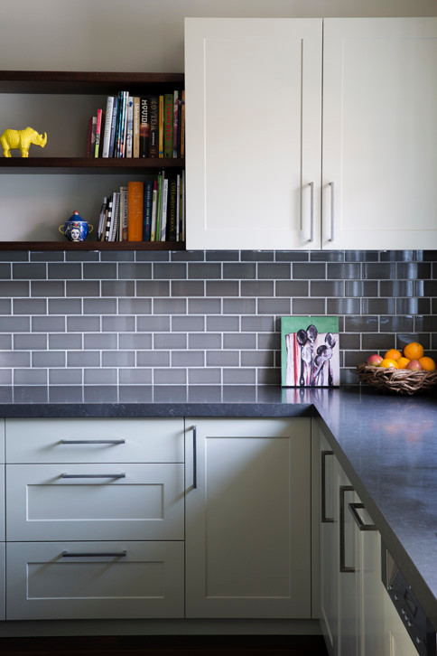 This is an example of a transitional kitchen in Sydney with recessed-panel cabinets and subway tile splashback.