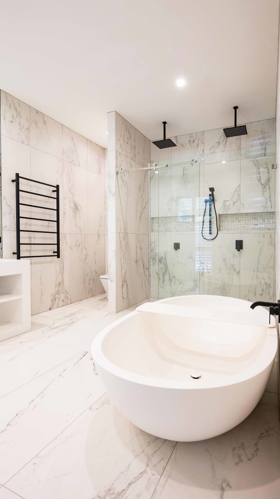Photo of a contemporary master bathroom in Melbourne with flat-panel cabinets, white cabinets, a freestanding tub, a double shower, white tile, marble, white walls, marble floors, an integrated sink, solid surface benchtops, white floor and a sliding shower screen.