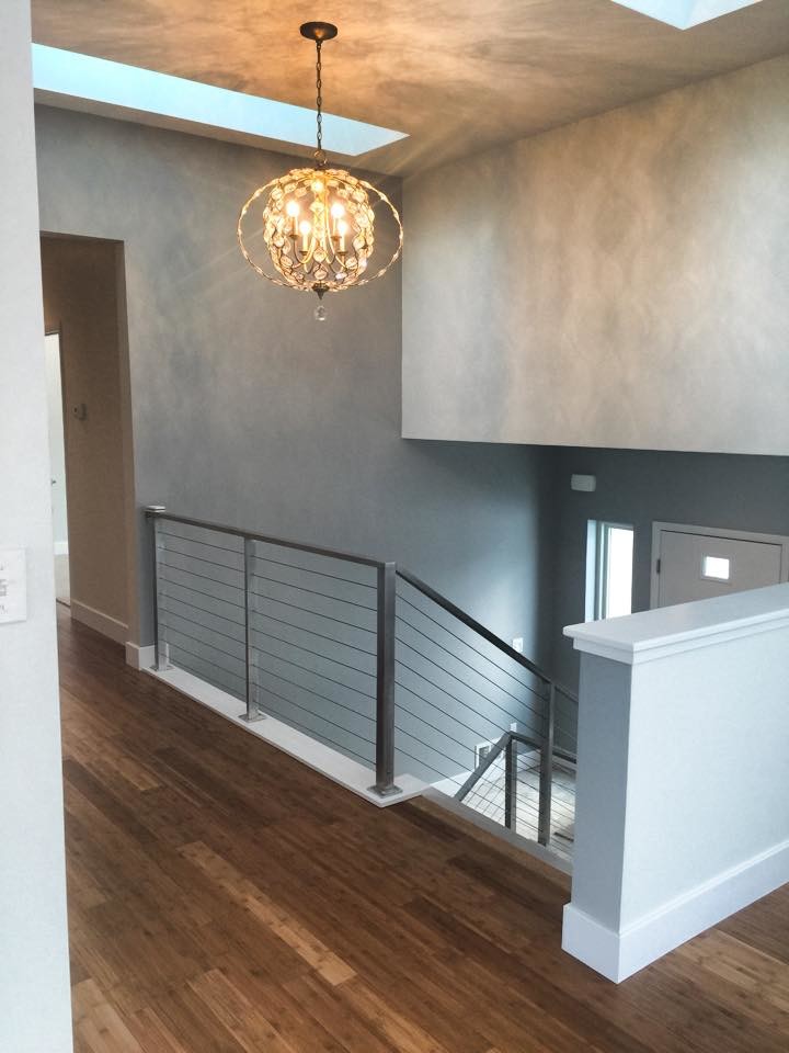 Large medium tone wood floor hallway photo with gray walls