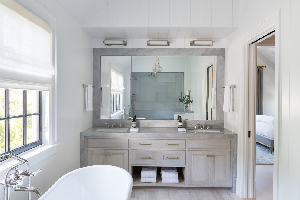 Photo of a transitional master bathroom in New York with recessed-panel cabinets, grey cabinets, white walls, light hardwood floors, an undermount sink, beige floor and grey benchtops.