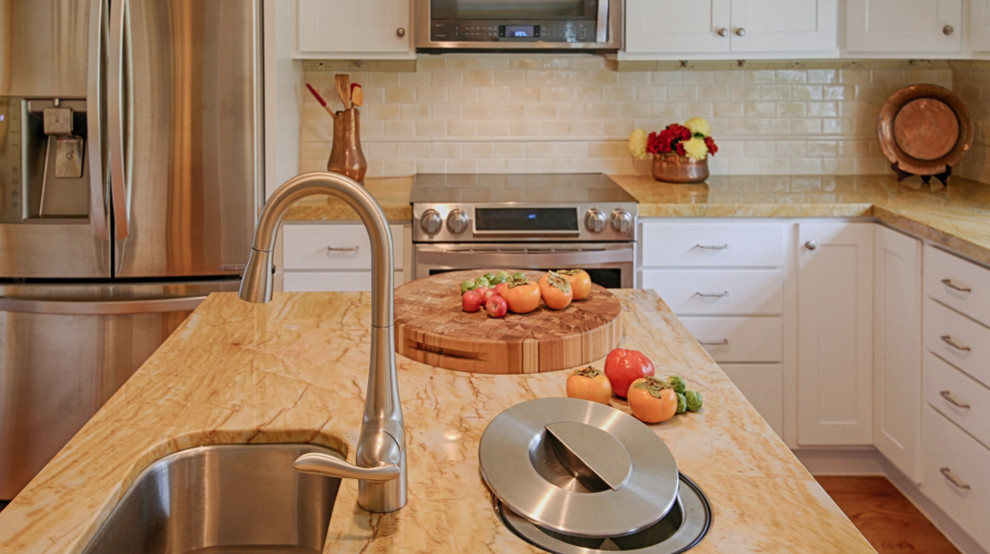 Transitional l-shaped medium tone wood floor kitchen photo with an undermount sink, flat-panel cabinets, white cabinets, beige backsplash, stainless steel appliances and an island