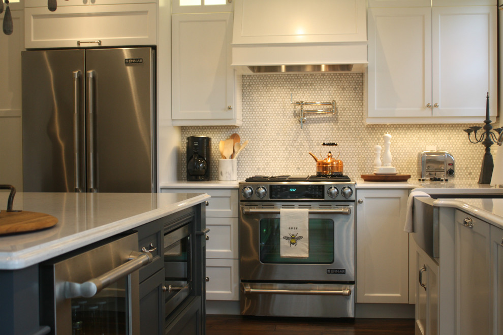 Mid-sized transitional l-shaped kitchen photo with shaker cabinets, white cabinets, white backsplash, stainless steel appliances, an island, a double-bowl sink and mosaic tile backsplash