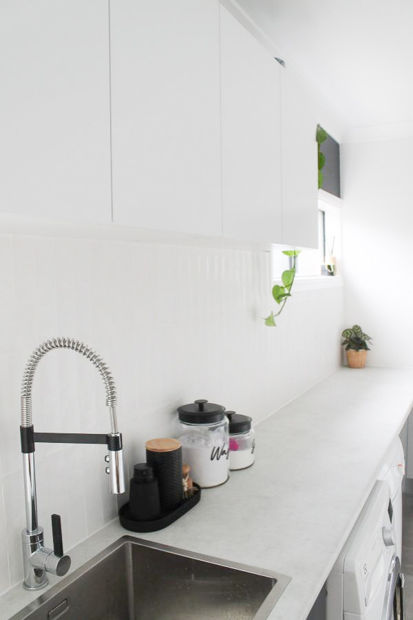 Mid-sized single-wall utility room in Perth with a drop-in sink, raised-panel cabinets, white cabinets, copper benchtops, ceramic splashback, white walls, porcelain floors, a side-by-side washer and dryer, grey floor and multi-coloured benchtop.