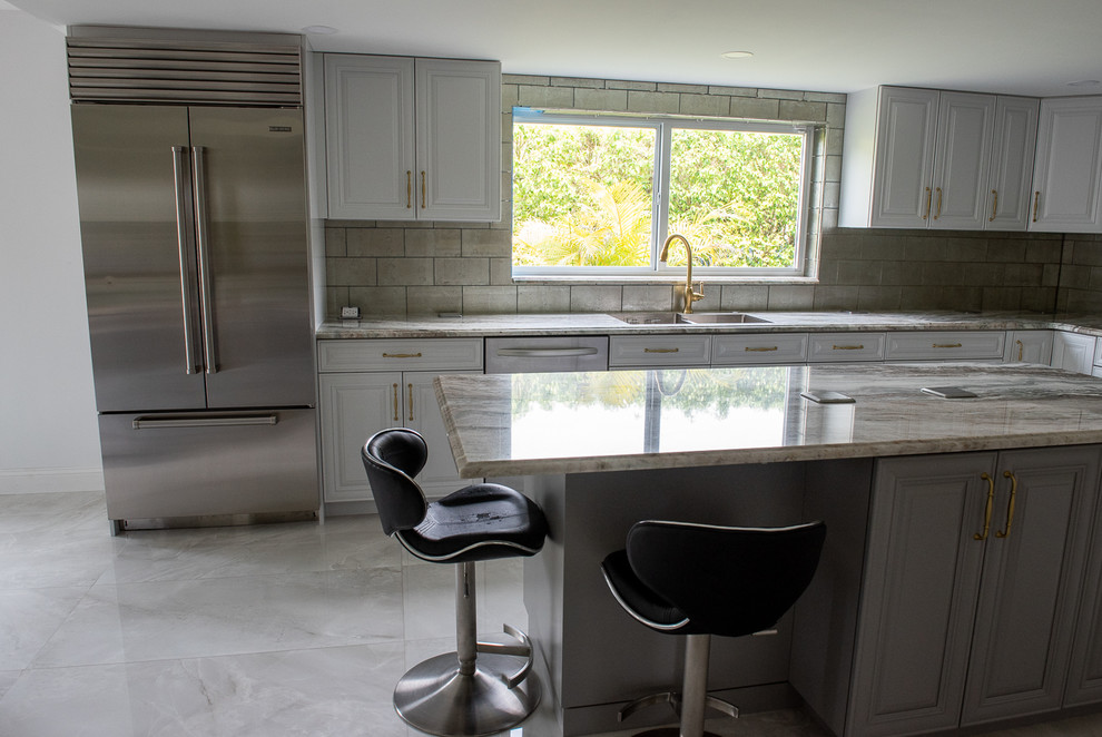 Photo of a large transitional u-shaped eat-in kitchen in Miami with quartzite benchtops and multiple islands.