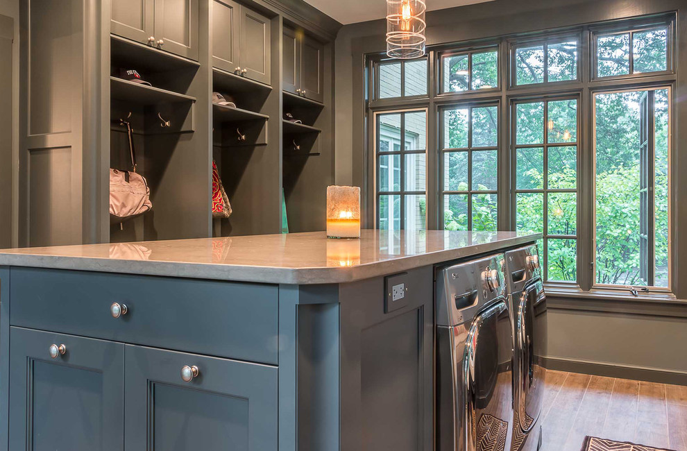Large scandinavian utility room in Chicago with an undermount sink, flat-panel cabinets, grey cabinets, quartz benchtops, grey walls, medium hardwood floors and a side-by-side washer and dryer.