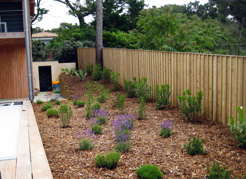 Photo of a mid-sized beach style front yard full sun garden for summer in Bordeaux with decking and a garden path.
