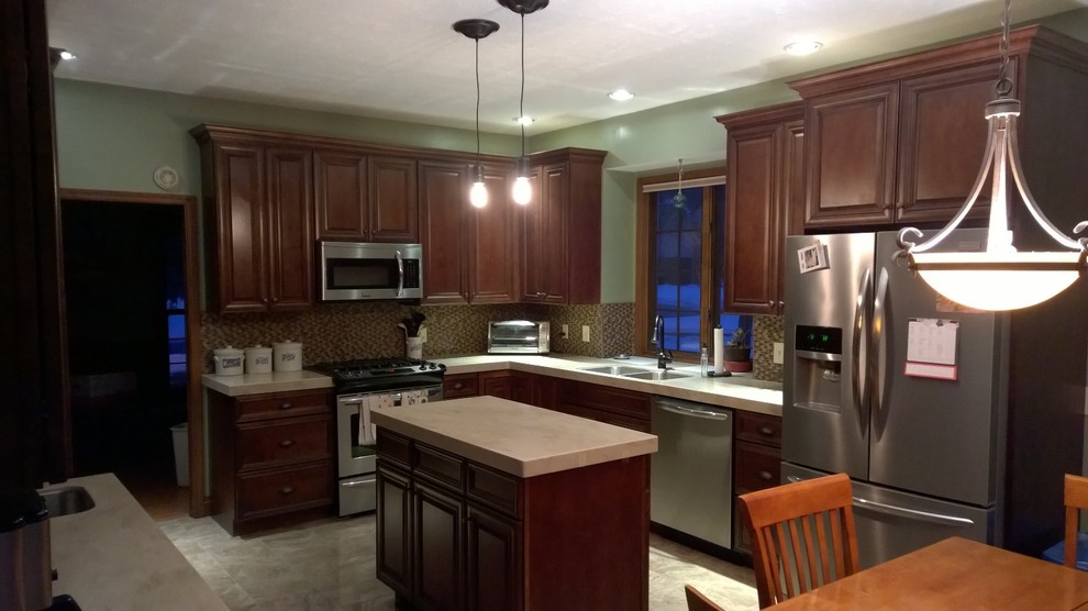 Eat-in kitchen - mid-sized traditional l-shaped porcelain tile eat-in kitchen idea with a double-bowl sink, raised-panel cabinets, dark wood cabinets, quartz countertops, multicolored backsplash, mosaic tile backsplash, stainless steel appliances and an island