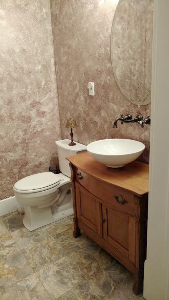 Photo of a mid-sized traditional 3/4 bathroom in Other with a vessel sink, shaker cabinets, medium wood cabinets, a two-piece toilet, beige walls, limestone floors, wood benchtops and beige floor.
