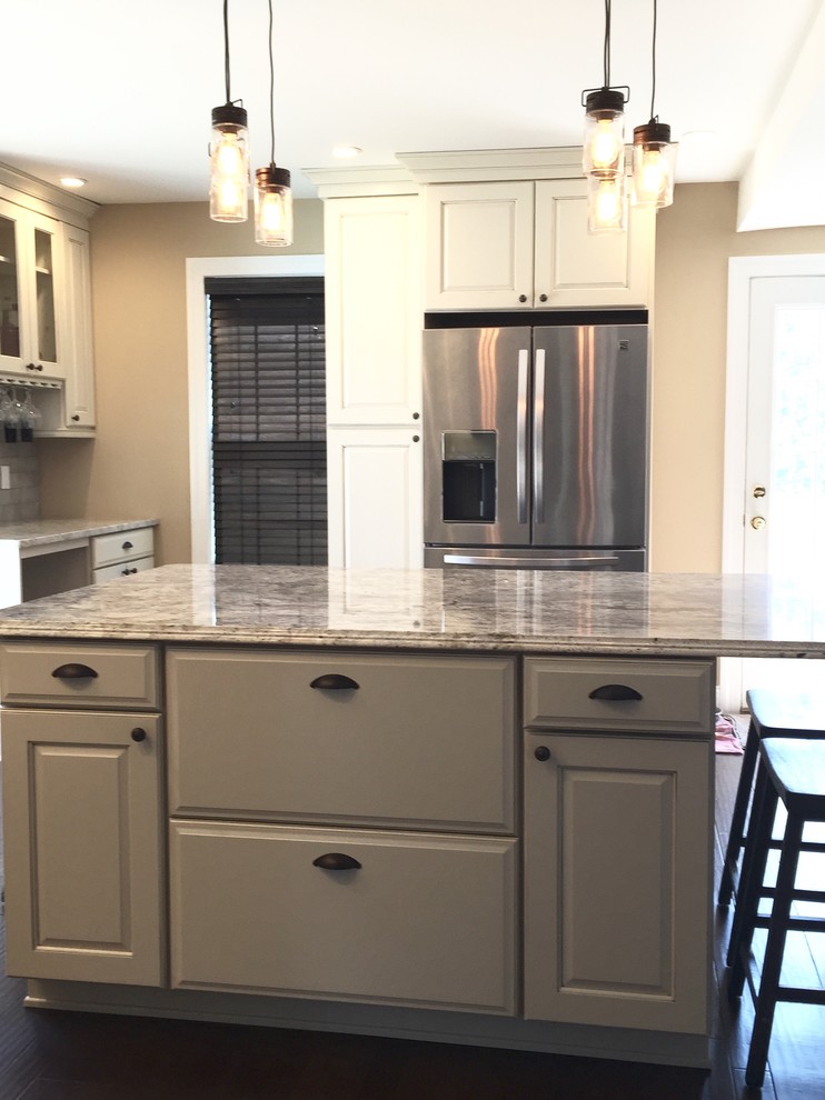 Example of a large transitional u-shaped dark wood floor and brown floor eat-in kitchen design in Atlanta with an undermount sink, raised-panel cabinets, beige cabinets, granite countertops, beige backsplash, glass tile backsplash, stainless steel appliances, an island and multicolored countertops