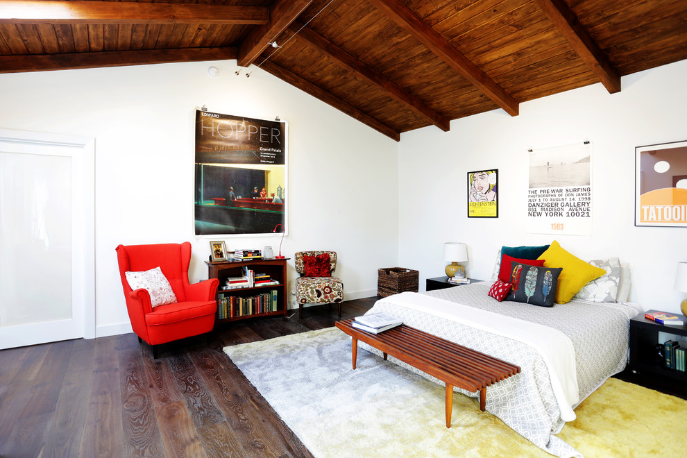 Photo of a transitional bedroom in Los Angeles with white walls, dark hardwood floors and brown floor.