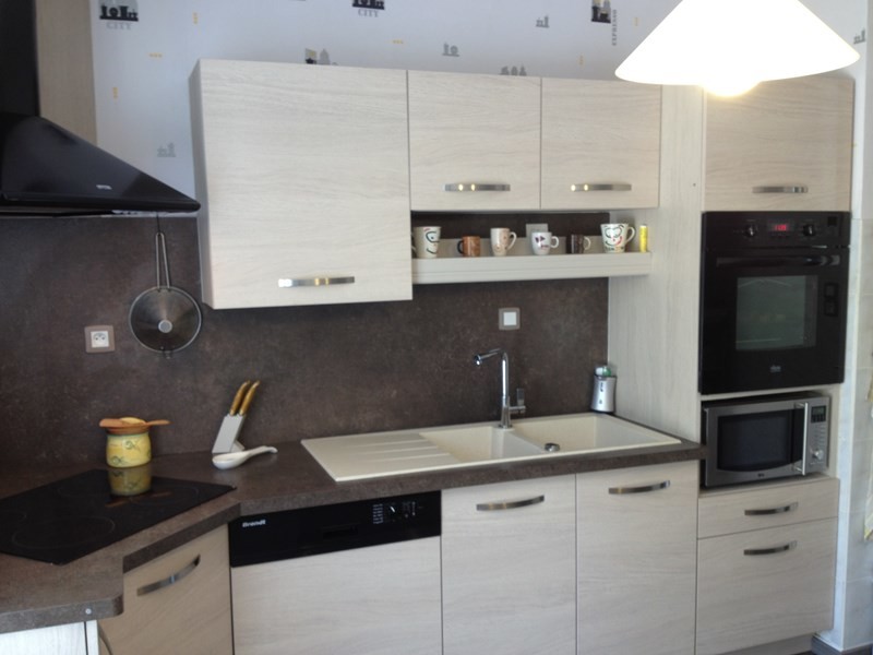 Photo of a mid-sized contemporary l-shaped separate kitchen in Lyon with a double-bowl sink, beaded inset cabinets, light wood cabinets, laminate benchtops, grey splashback, panelled appliances, medium hardwood floors, no island, brown floor and grey benchtop.