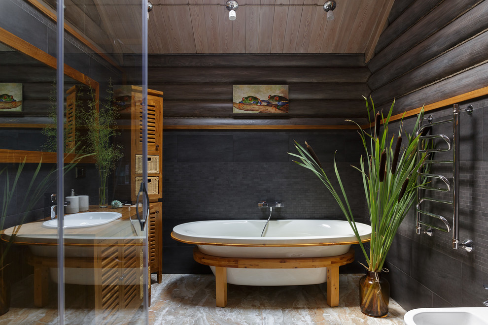 Design ideas for a country master bathroom in Moscow with a freestanding tub, black tile, mosaic tile, black walls, a drop-in sink and beige floor.