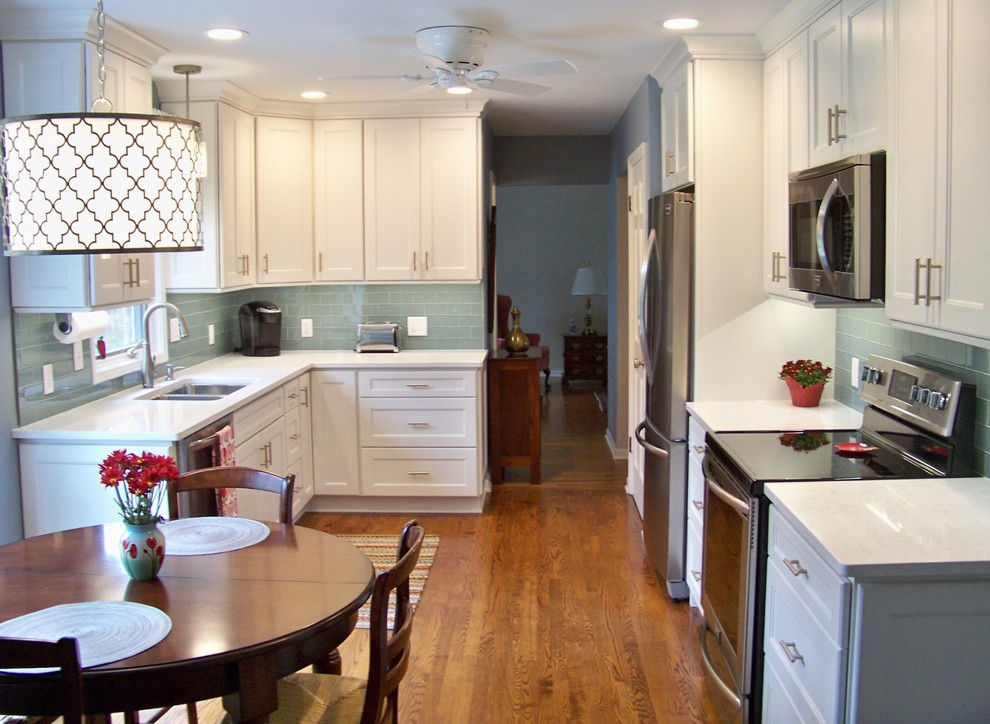 Mid-sized transitional u-shaped medium tone wood floor and brown floor eat-in kitchen photo in Chicago with a double-bowl sink, recessed-panel cabinets, white cabinets, quartz countertops, green backsplash, glass tile backsplash, stainless steel appliances and no island