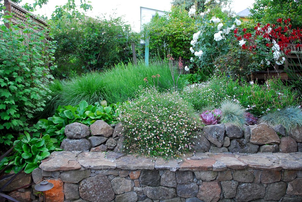 Inspiration for a mid-sized country sloped partial sun formal garden in San Francisco with a retaining wall and natural stone pavers.