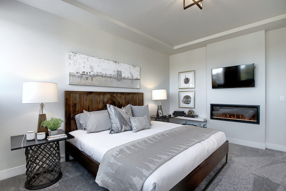 На фото: хозяйская спальня среднего размера в стиле лофт с серыми стенами, ковровым покрытием, стандартным камином, фасадом камина из штукатурки, серым полом и многоуровневым потолком с