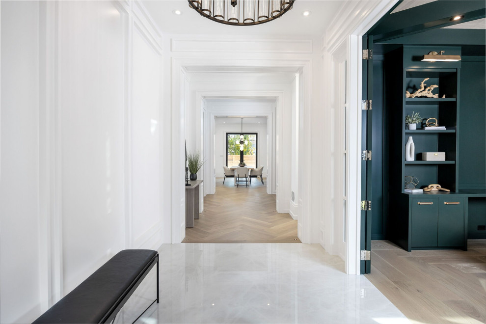 Design ideas for a mid-sized transitional hallway in Toronto with white walls, porcelain floors, white floor and panelled walls.