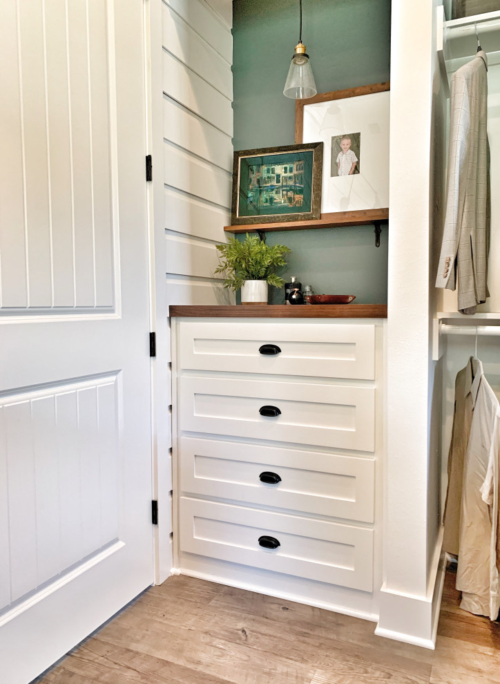 This is an example of a country gender-neutral storage and wardrobe with shaker cabinets, white cabinets, vinyl floors and grey floor.