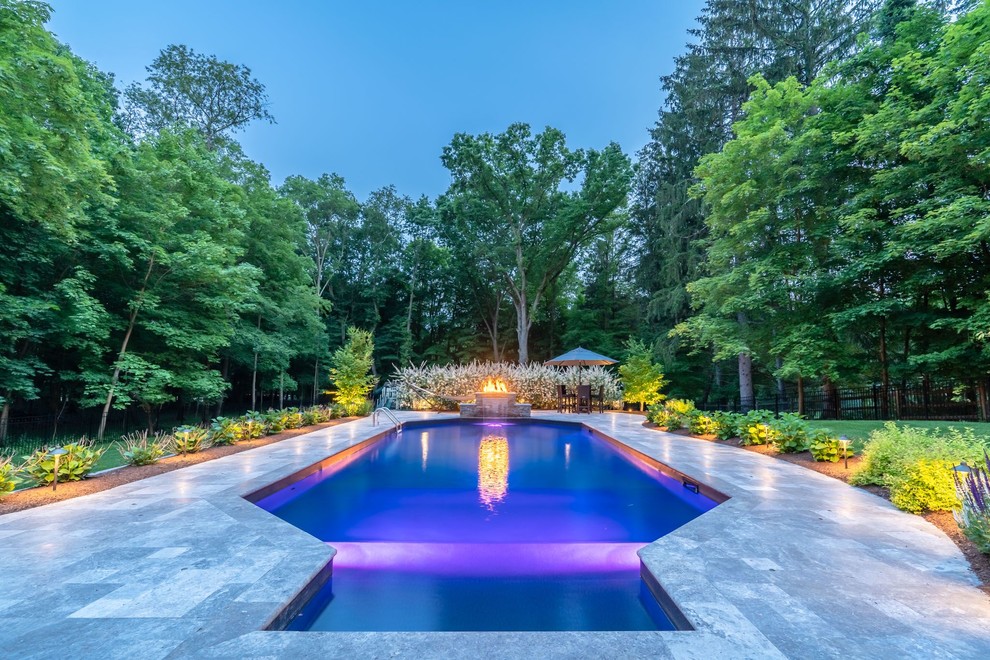 Large transitional backyard rectangular lap pool in New York with a water feature and natural stone pavers.