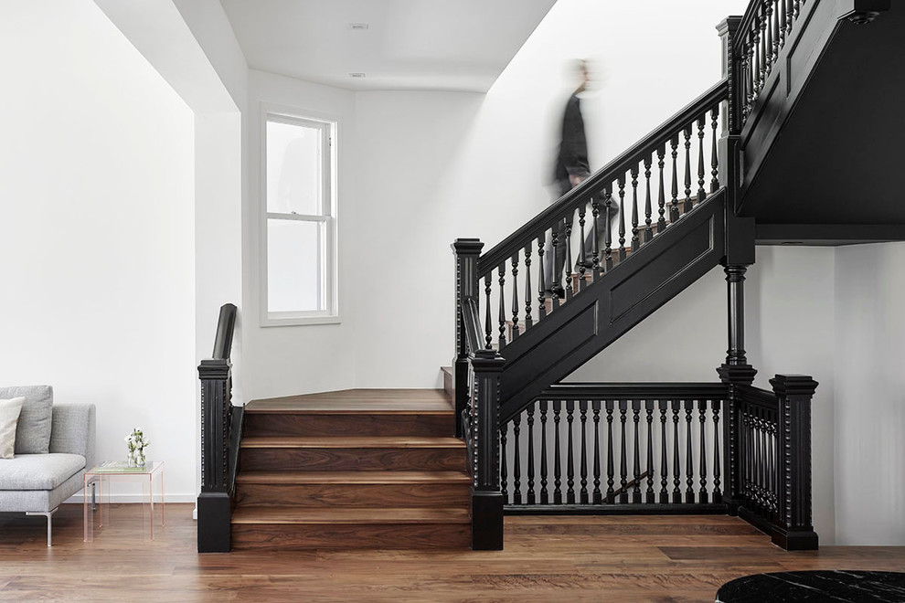 Photo of a large traditional wood u-shaped staircase in San Francisco with wood risers.