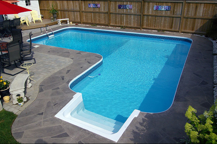 Pool - mid-sized transitional backyard concrete paver and custom-shaped lap pool idea in Toronto