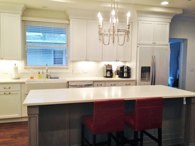Eat-in kitchen - mid-sized transitional l-shaped dark wood floor eat-in kitchen idea in Chicago with a farmhouse sink, recessed-panel cabinets, white cabinets, quartz countertops, white backsplash, ceramic backsplash, stainless steel appliances and an island