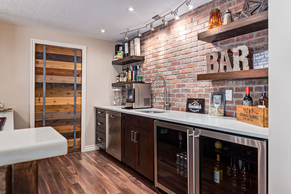 Photo of a mid-sized country home bar in Calgary with laminate floors and brown floor.