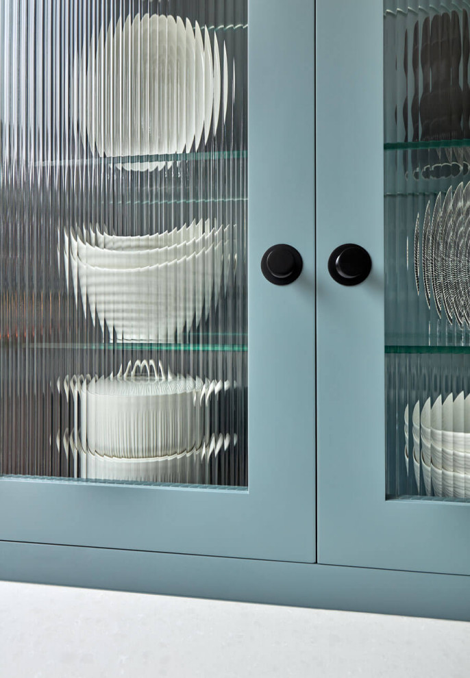 Bild på ett avskilt, mellanstort funkis vit vitt kök, med skåp i shakerstil, blå skåp, bänkskiva i kvartsit, integrerade vitvaror, kalkstensgolv, en köksö och grått golv