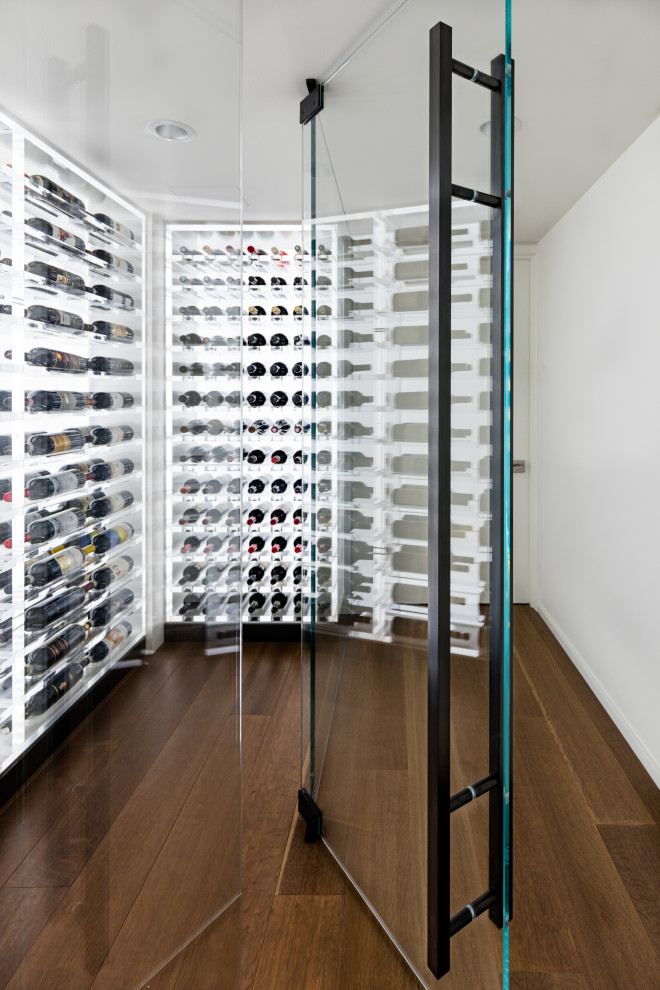 This is an example of a small modern wine cellar in Seattle with light hardwood floors, storage racks and brown floor.