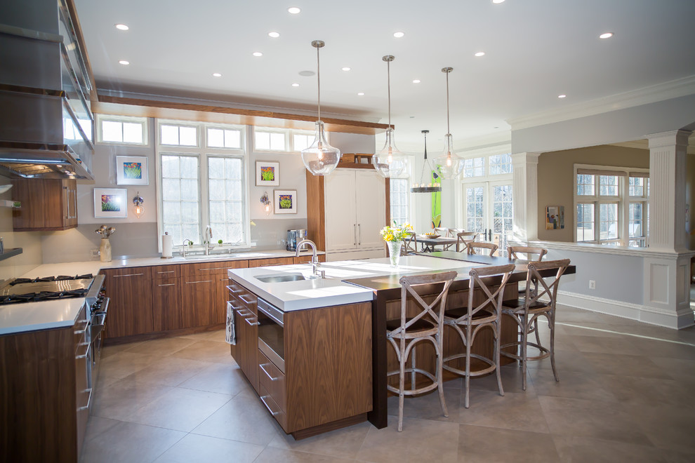 Large transitional l-shaped beige floor and cement tile floor open concept kitchen photo in DC Metro with an undermount sink, flat-panel cabinets, medium tone wood cabinets, beige backsplash, stainless steel appliances, an island, solid surface countertops, glass tile backsplash and white countertops