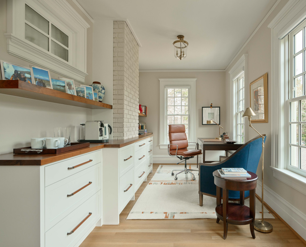 Transitional freestanding desk light wood floor and beige floor home office photo in Raleigh with beige walls
