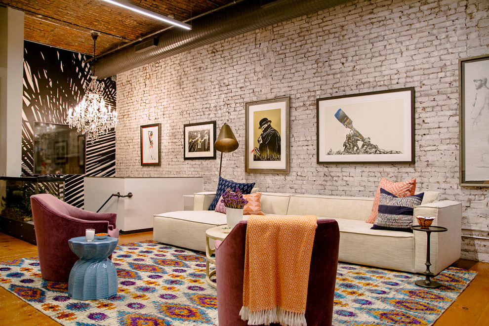 Photo of an eclectic formal loft-style living room in New York with multi-coloured walls, medium hardwood floors and brown floor.