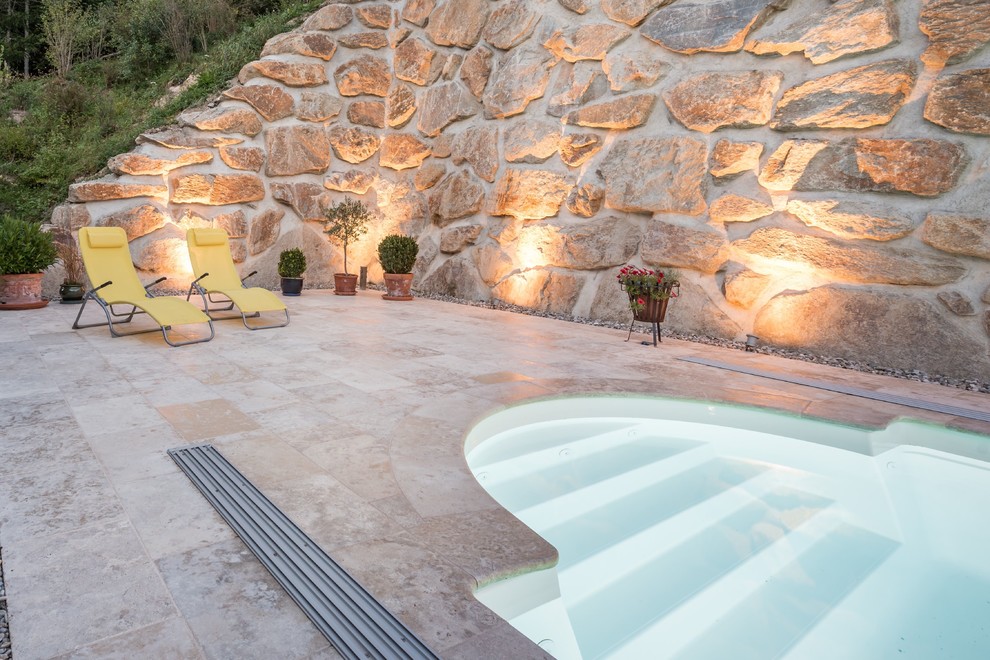 Large backyard stone and custom-shaped lap pool photo in New York