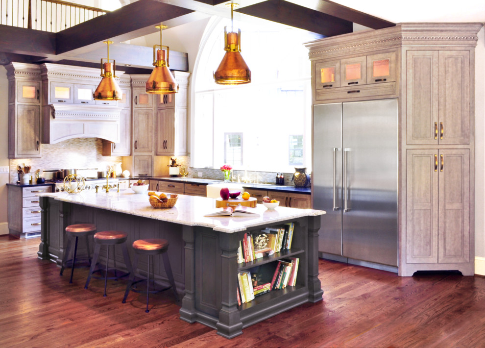 Inspiration for a large transitional l-shaped medium tone wood floor kitchen remodel in DC Metro with a farmhouse sink, recessed-panel cabinets, gray cabinets, granite countertops, gray backsplash, glass tile backsplash, stainless steel appliances and an island