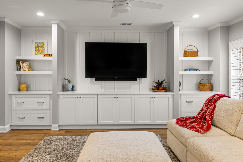 Example of a mid-sized minimalist open concept medium tone wood floor and brown floor family room design in Atlanta with a bar, gray walls and a wall-mounted tv