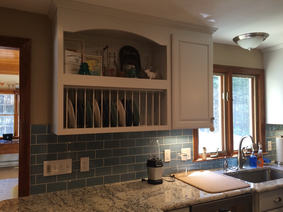 Example of a transitional u-shaped medium tone wood floor eat-in kitchen design in Boston with an undermount sink, raised-panel cabinets, white cabinets, granite countertops, blue backsplash, glass tile backsplash, stainless steel appliances and an island
