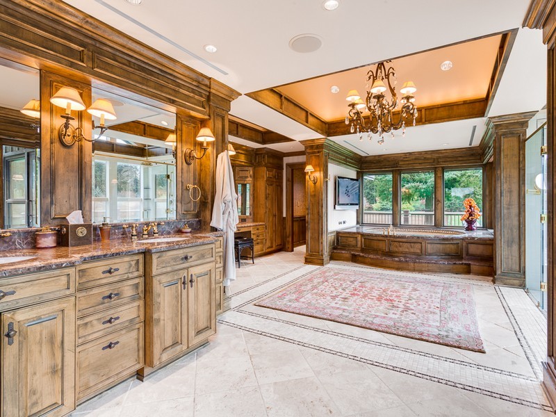 Inspiration for an arts and crafts master bathroom in Seattle with an undermount sink, furniture-like cabinets, distressed cabinets, granite benchtops, an undermount tub, brown walls and ceramic floors.