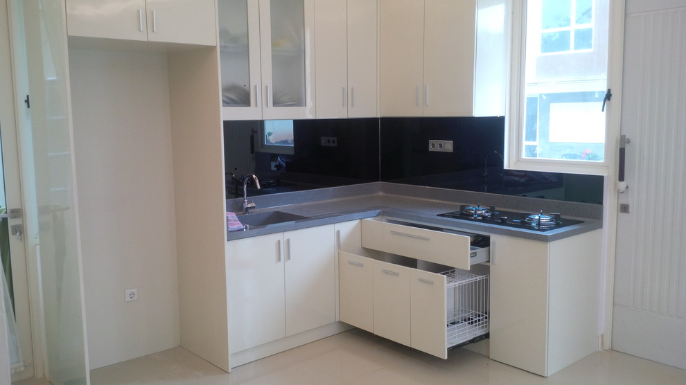Small asian l-shaped kitchen pantry in Other with a drop-in sink, flat-panel cabinets, white cabinets, solid surface benchtops, black splashback, glass sheet splashback, black appliances, marble floors and no island.