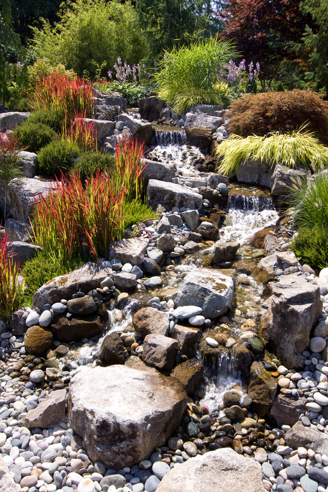 Photo of a country garden in Vancouver with with waterfall and river rock.